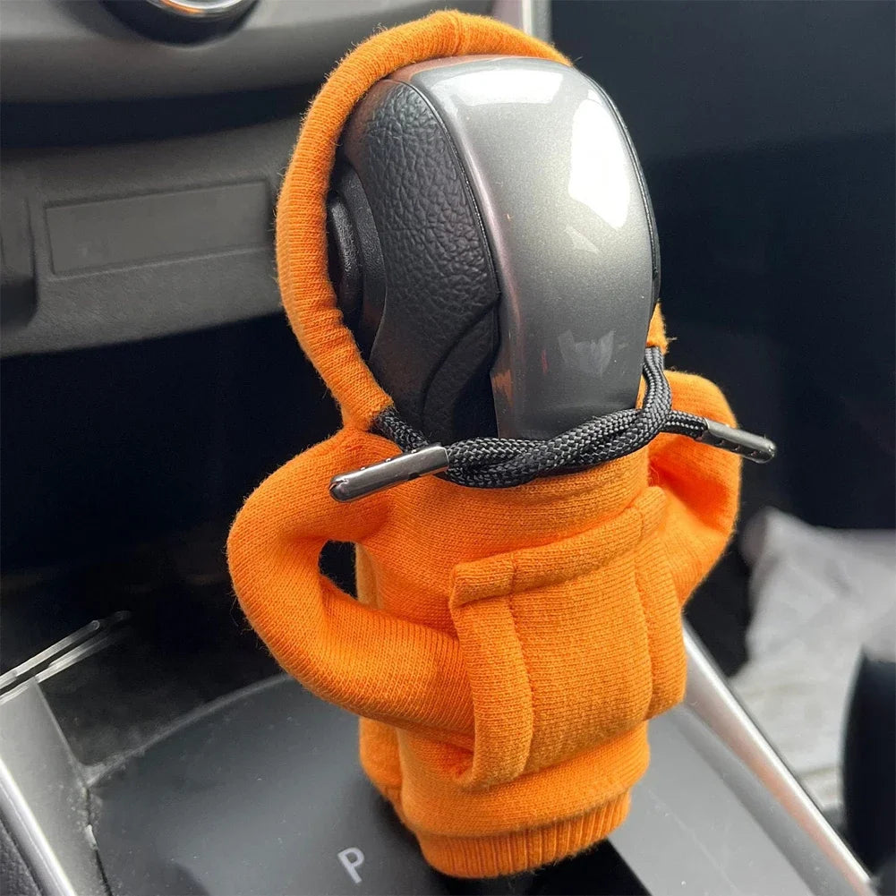 Car gear shift cover with orange hoodie and black braided rope in a car interior.