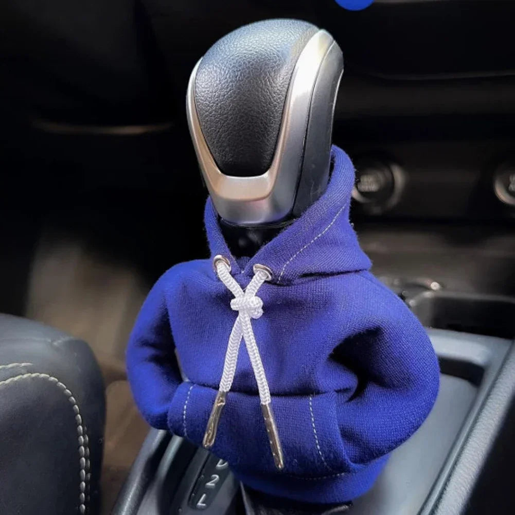 Car gear shift covered with a blue hoodie inside a vehicle.