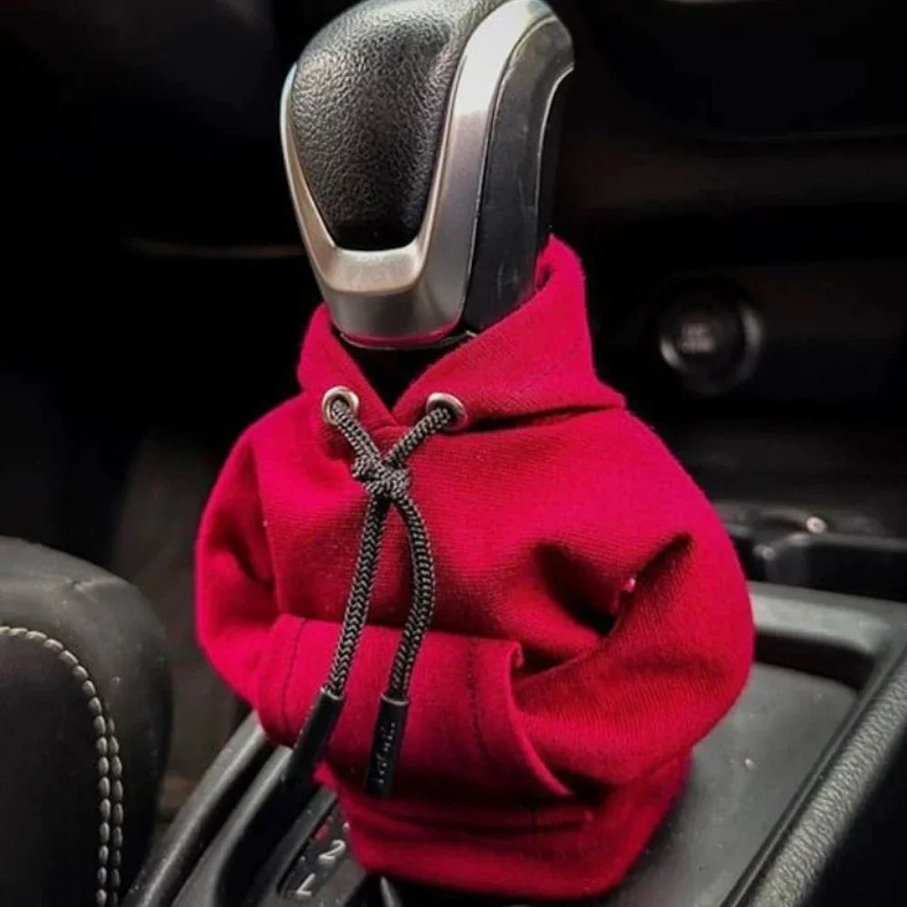 Car gear shift covered with a red hoodie inside a vehicle.