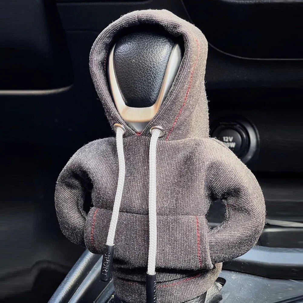 Car headrest cover shaped like a person wearing a hoodie inside a vehicle.