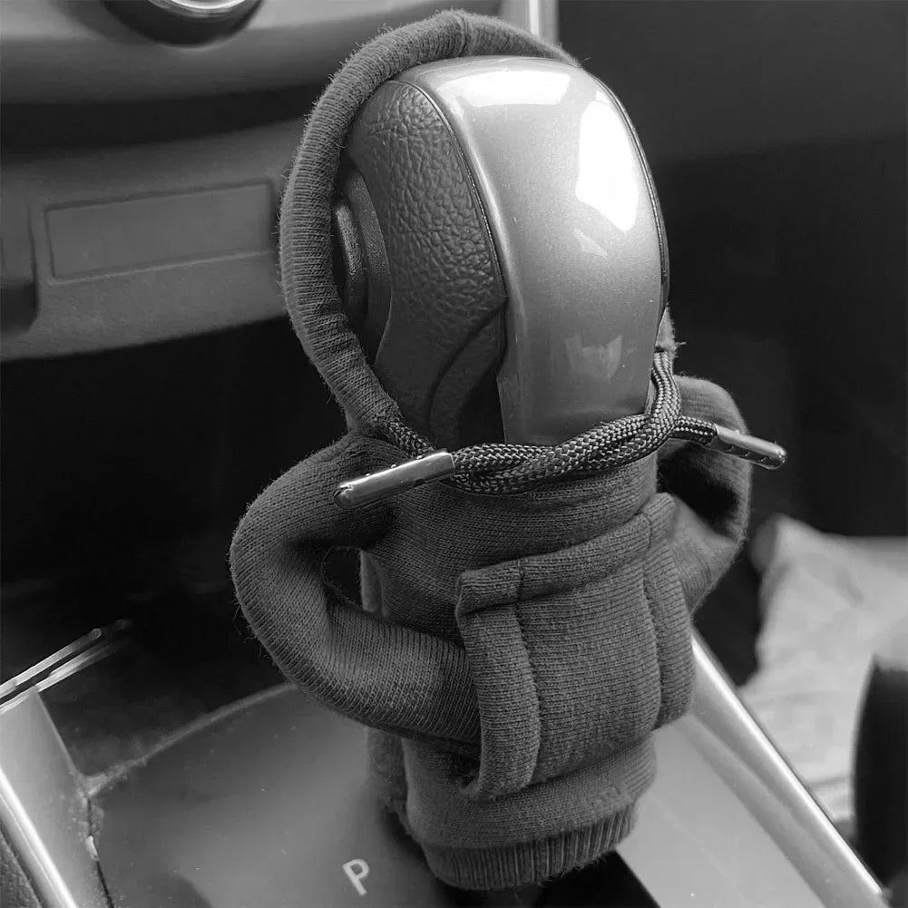 Pair of gloves holding a car gear shift lever