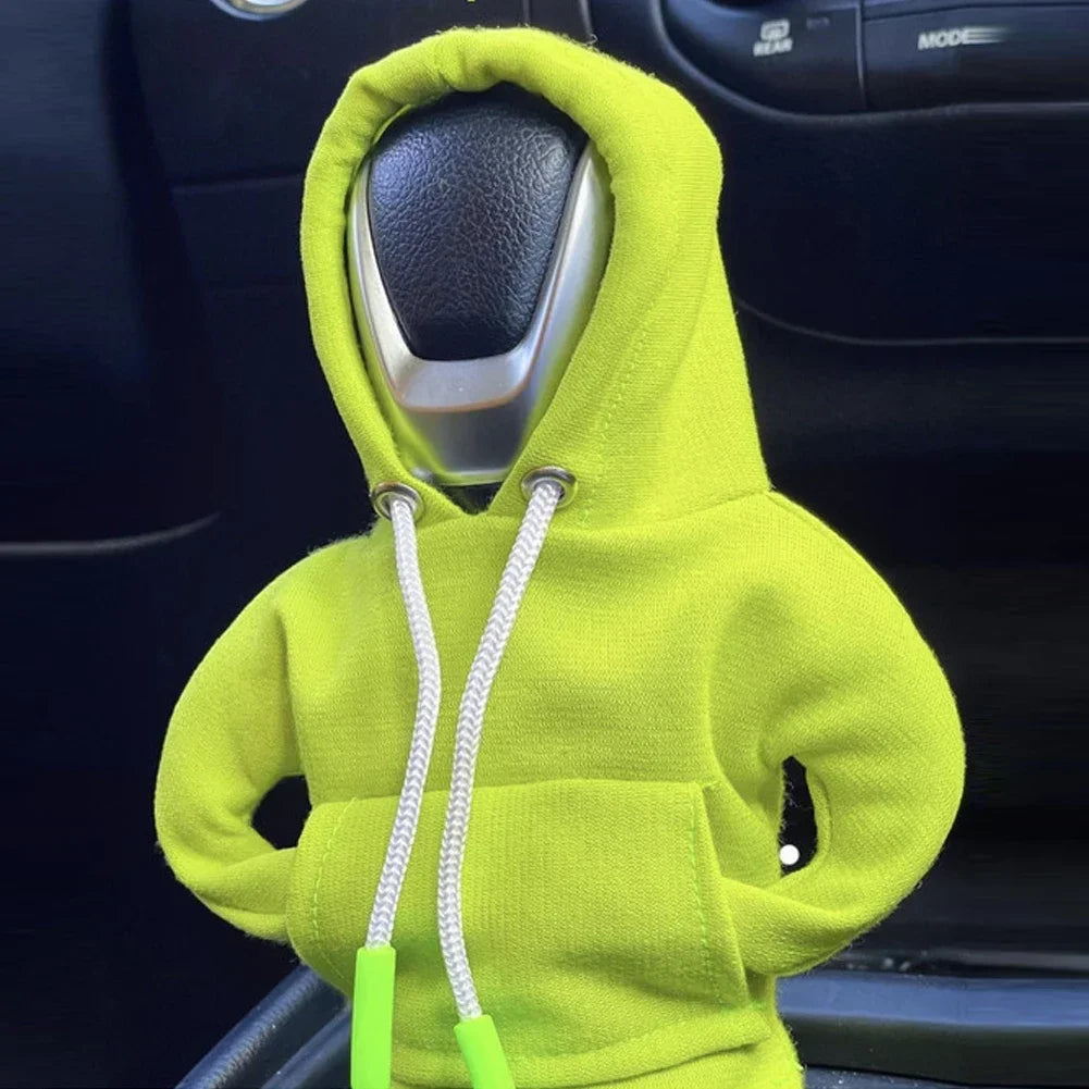 Person wearing a bright green hoodie inside a car, with the hood over the gear shift.