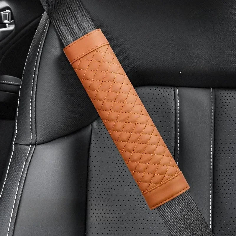 Brown quilted car seat belt cover on a gray car seat