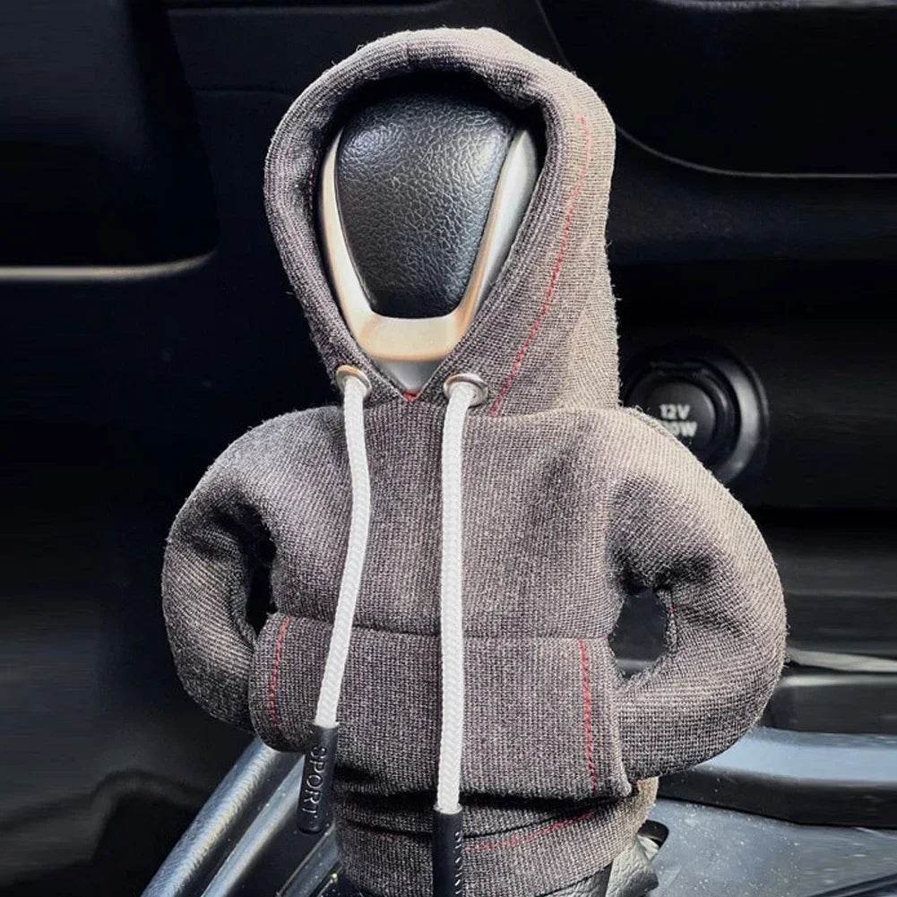 Car headrest cover shaped like a person wearing a hoodie inside a vehicle.