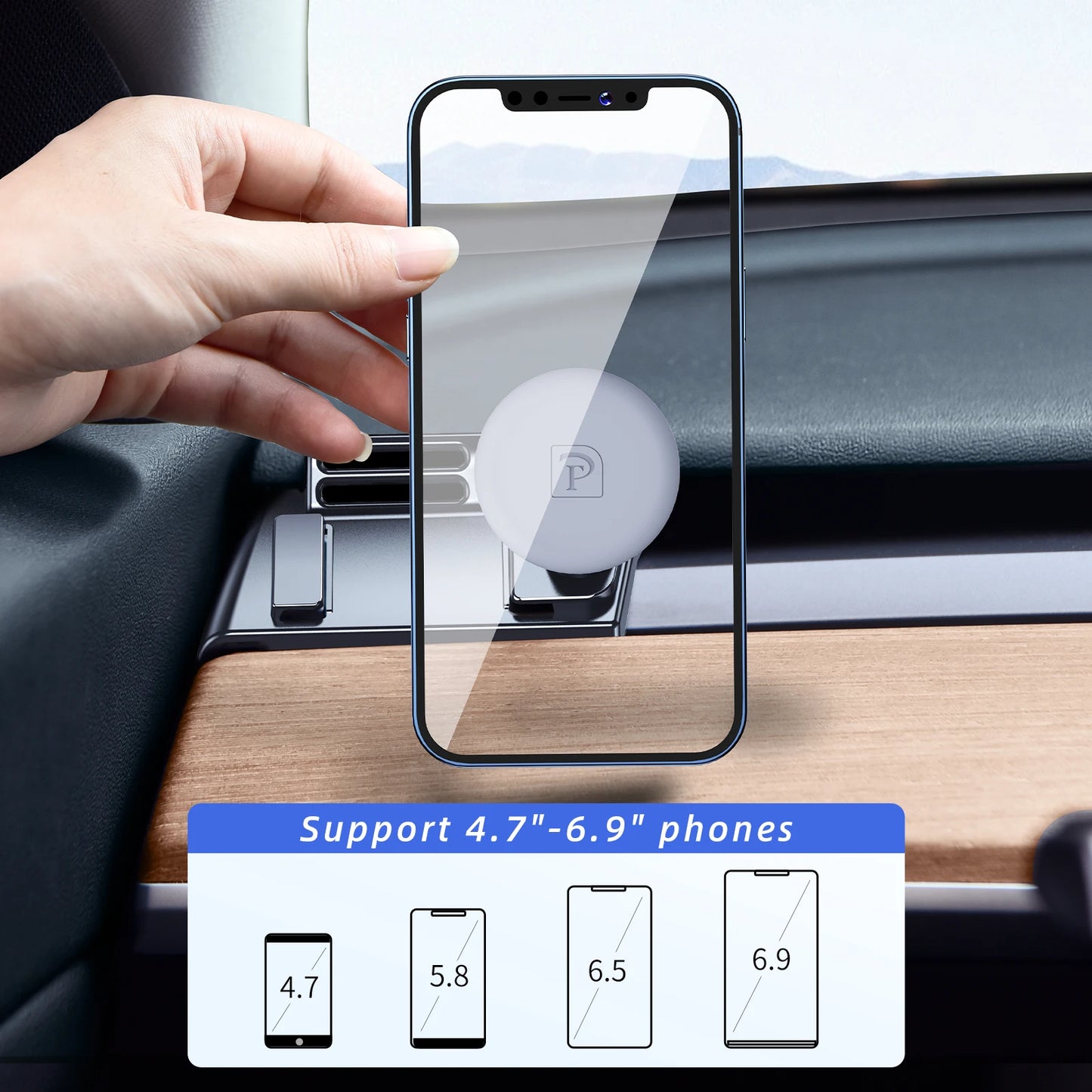 Hand holding a smartphone with a screen protector, placed on a car dashboard.
