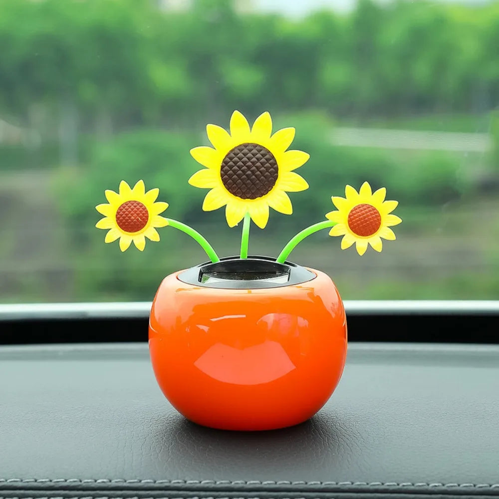 Orange car dashboard decor with sunflower design on a blurred green outdoor background
