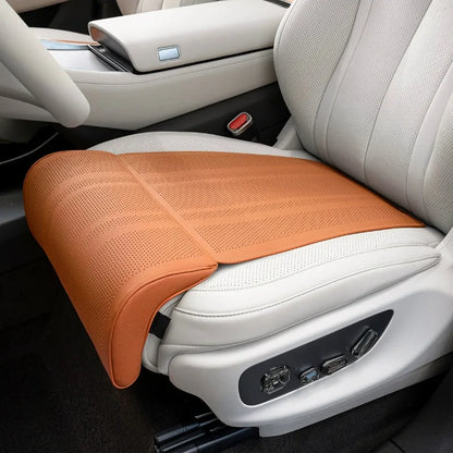 Orange car seat cushion on a white car seat