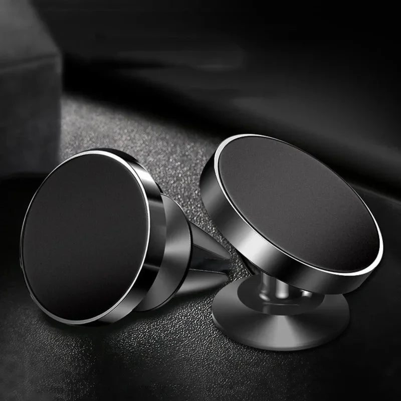 Two metallic phone holders on a dark textured surface